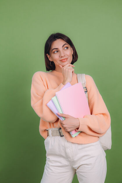 情感穿着休闲桃色毛衣的年轻女子被隔离在绿橄榄色的墙上成功教育学习