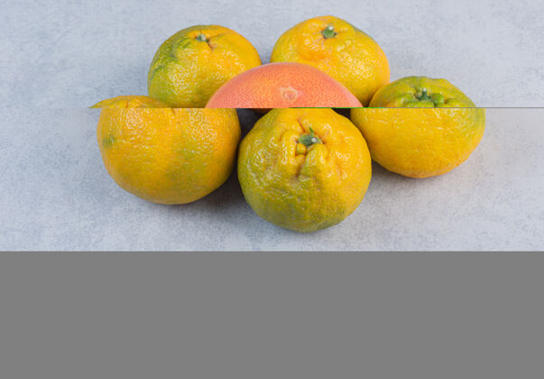堆灰色背景上的有机橘子（橘子 桔子 柑橘类水果）柑橘美味克莱门汀