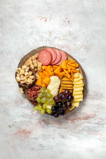 葡萄俯视不同零食坚果cips葡萄奶酪和香肠白色表面坚果零食餐食品水果香肠浆果坚果