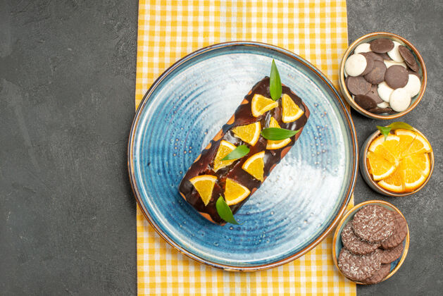 晚餐黄色条纹毛巾和饼干上点缀着橘子和巧克力的美味蛋糕美味蛋糕食物餐点
