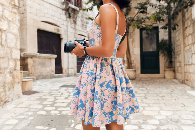 春天在意大利老城区度假时 一个穿着长裙的漂亮女人在用相机拍照装束衣服旅游