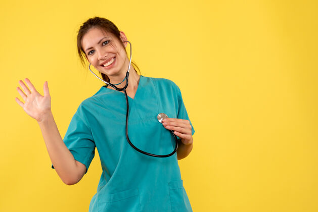 健康正面图黄色背景 穿着医用衬衫 带听诊器的女医生医学观点衬衫