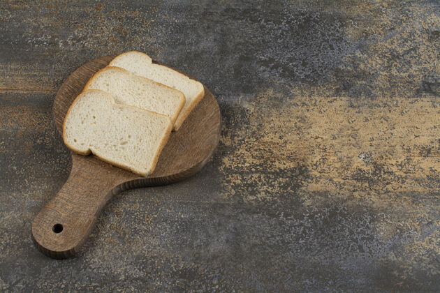 面包皮在木砧板上放几片白吐司面包食品面包房切片