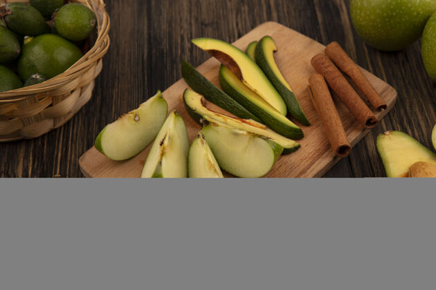 蔬菜健康的鳄梨切片放在木制厨房板上 肉桂条和苹果切片放在木制表面肉桂配料食物