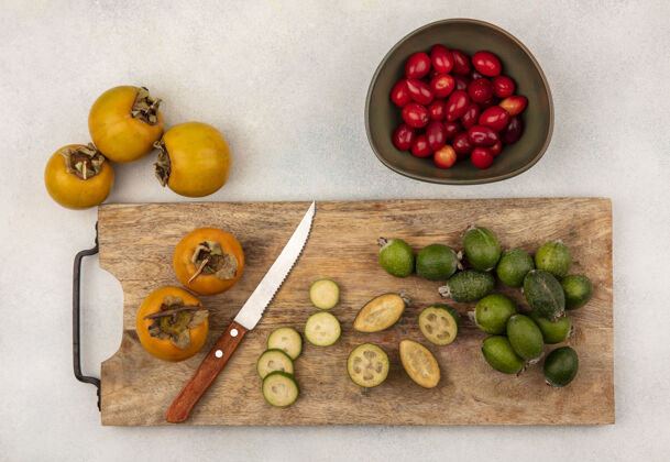 营养在灰色表面的碗上放着柿子和小刀的木制厨房板上的半个和整个飞珠的俯视图樱桃饮食木材
