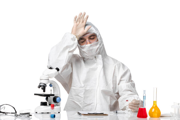 大流行正面图：男医生穿着防护服 戴着面罩 因为白色空间上有一个装着柯维德的瓶子男医生化学专业