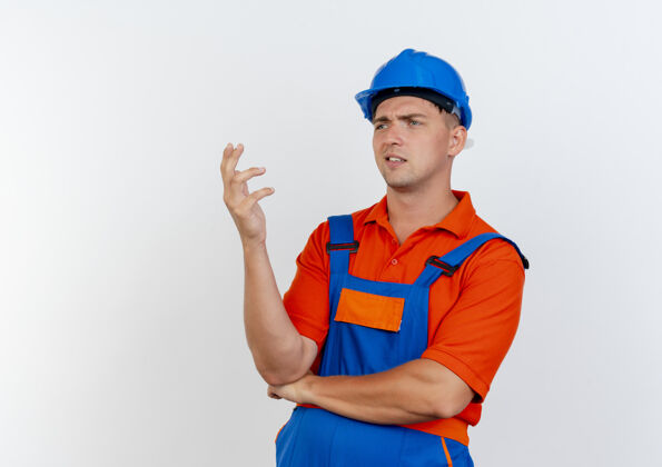 混乱看着身边迷茫的年轻男建筑工人穿着制服 戴着安全帽举手男人壁板工人