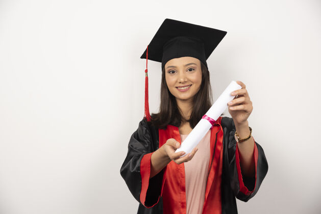 帽子在白色背景上展示毕业证书的研究生学术女性年轻