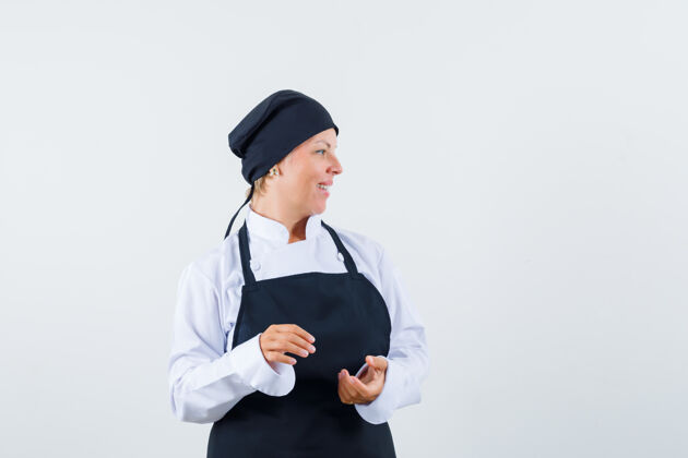 围裙女厨师身着制服 围裙 面容开朗 俯瞰前方健康年轻成人