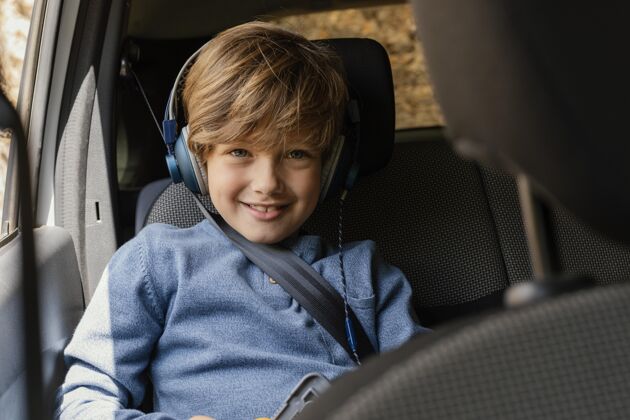 家庭肖像男孩在车里戴着耳机听音乐耳机孩子探索