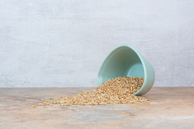 堆大麦粒从碗里出来放在大理石表面大麦麦芽自然