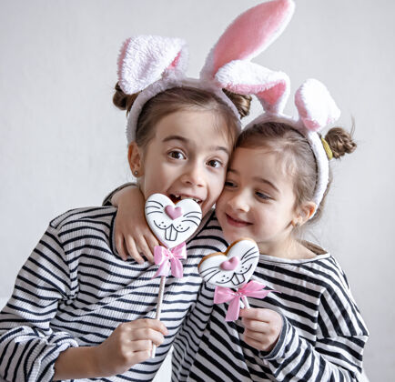 兔子有趣的小女孩 头上戴着复活节耳朵 树枝上放着复活节姜饼肖像食物兔子
