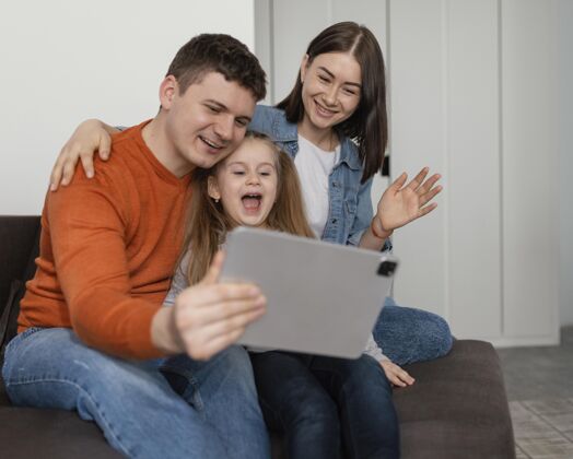 童年快乐的孩子和家长与平板电脑中镜头科技父亲
