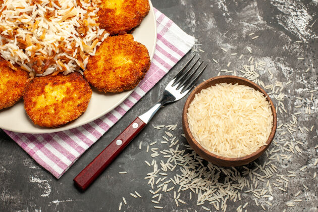 午餐俯视图油炸肉排 米饭和生米放在深色的烤肉盘上晚餐景观美味