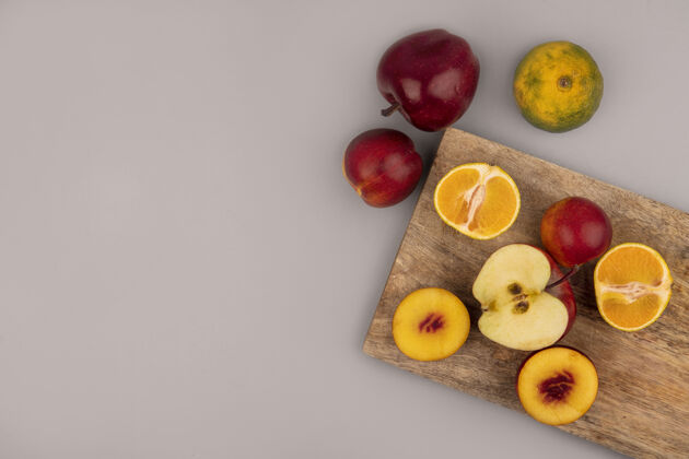 膳食顶视图的水果 如桃子 苹果和橘子孤立在一个木制的厨房板上的灰色墙壁与复制空间水果橘子顶部