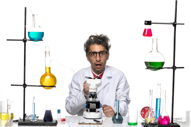 科学前视图穿着白色医疗服的男科学家坐着 表情困惑人化学实验室