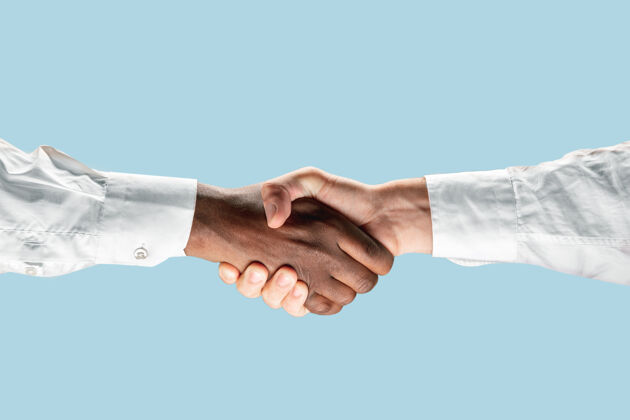 业务员共同规划未来的标志团队合作和交流两个男人的手在蓝色背景上孤立地握手会议业务员手势