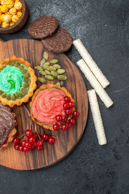 盘子俯瞰美味的奶油蛋糕和水果在黑暗的桌子上甜饼干饼干健康饼干食物