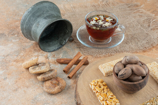 茶壶一杯凉茶配上古老的水壶和花生脆坚果美味的草药