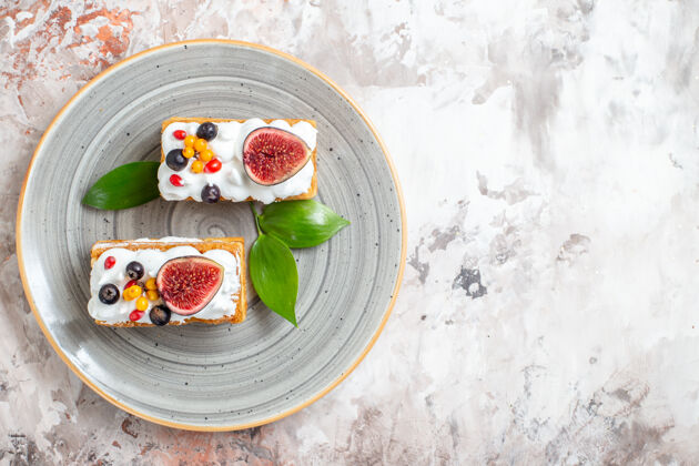 甜点顶视图美味的奶油蛋糕与新鲜水果的光背景草莓沙拉蛋糕