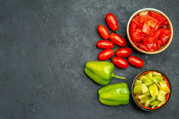 饮食顶视图的碗甜椒和西红柿与蔬菜的一面和自由空间为您的文本在深绿色的背景健康文字甜椒