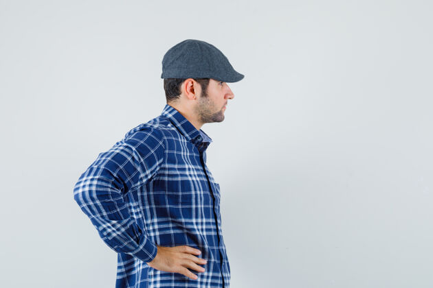 肖像穿着蓝色衬衫 戴着蓝色帽子的年轻男人在一旁看着男人模特男性