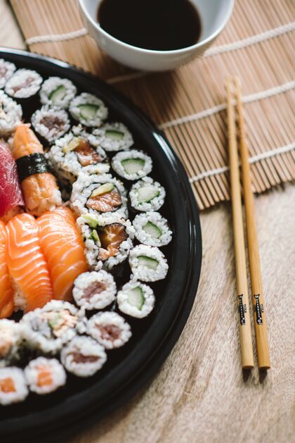 日本选择焦点拍摄美味的寿司卷在一个黑色的圆形盘子大米晚餐酱油