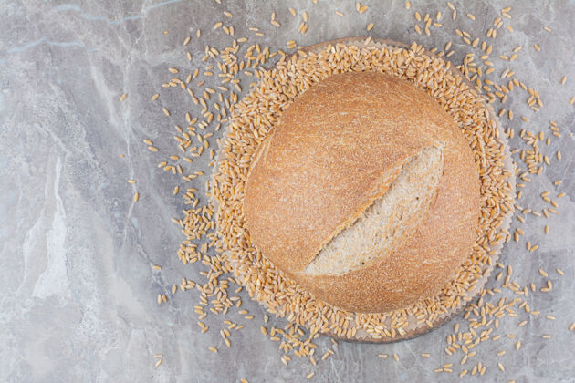 面包未煮的燕麦和面包放在大理石表面整个自然膳食