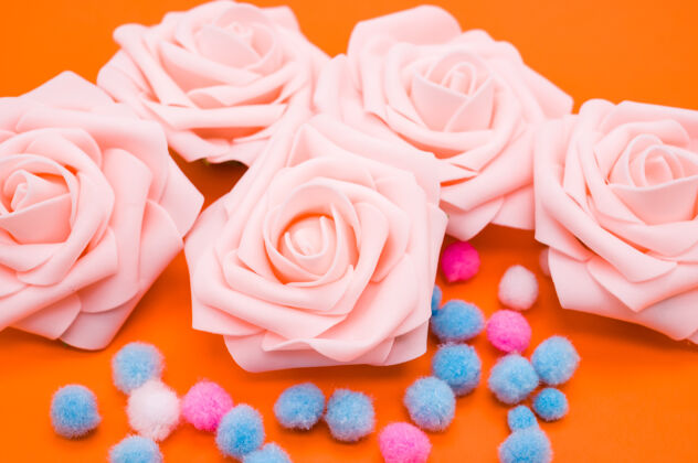 橙色粉红玫瑰和橙色背景上孤立的彩色蓬蓬的特写镜头开花情人节花束