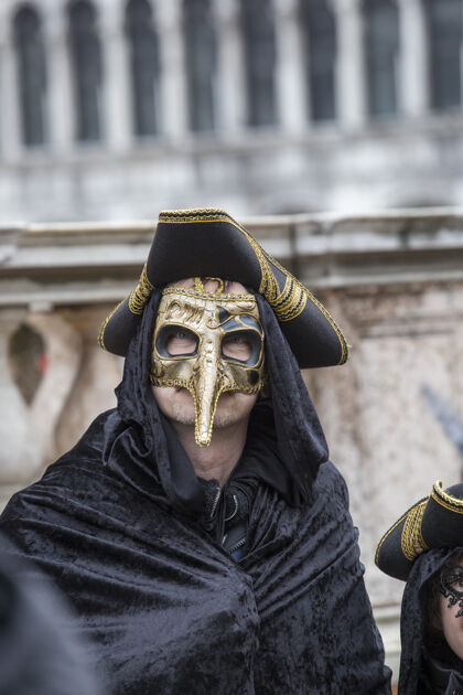 意大利语在举世闻名的狂欢节期间 一个戴着传统威尼斯面具的男人娱乐时尚面具