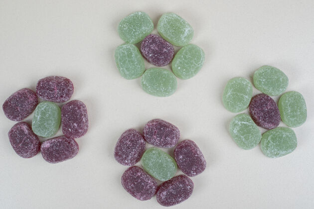 糖果绿色和紫色果冻糖果米色表面邦邦甜点明胶