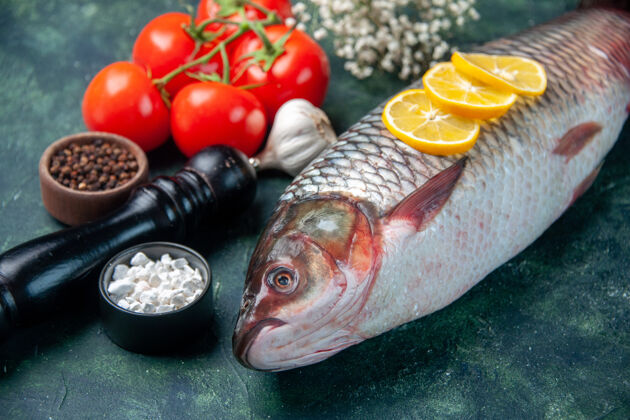 晚餐前视新鲜生鱼片 深蓝色表面上有西红柿和柠檬鲨鱼海鲜餐海洋横向晚餐食物动物水肉肉食物海洋