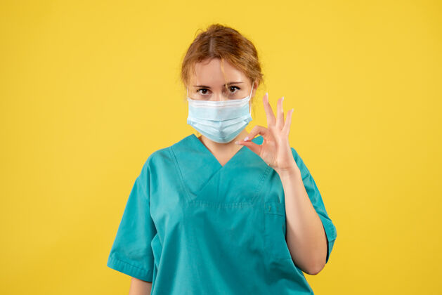 人物黄墙上年轻女医生穿着医疗服 戴着口罩的正面图封面正面防护罩