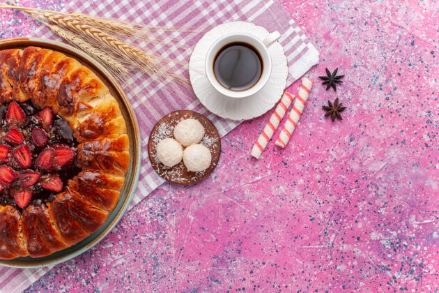 椰子俯瞰美味的草莓馅饼圆形水果蛋糕上的粉红色咖啡杯子糖果