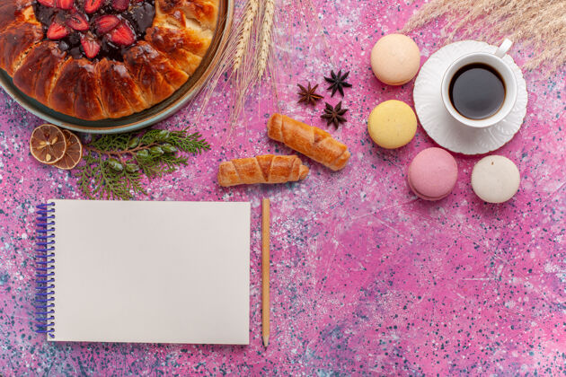 咖啡顶视图美味的草莓派与一杯茶和麦卡龙粉红水果杏仁饼茶
