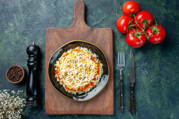 盘子顶视图美味含羞草沙拉在盘子里与深蓝色背景上的红色西红柿顶部晚餐菜肴