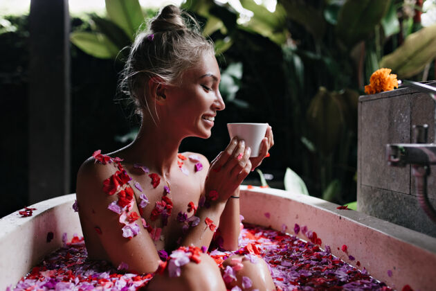 卫生快乐的年轻女士在早晨的水疗放松 喝着可口的茶迷人的金发女模特在周末洗澡时微笑着情感水治疗