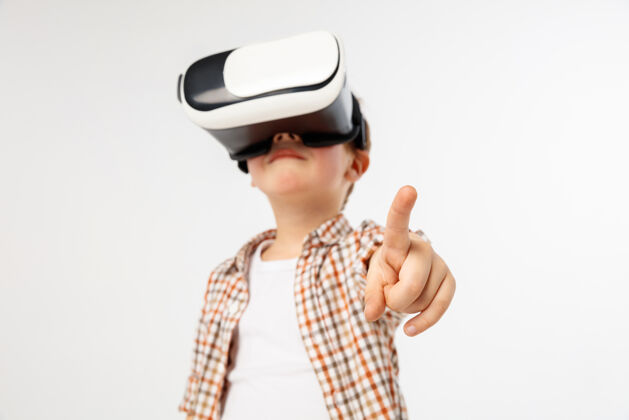现实孩子指着前面用虚拟现实眼镜隔离游戏眼镜男孩