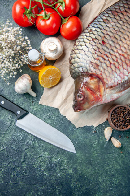 红色顶视图新鲜的生鱼肉与红色西红柿和蘑菇在深蓝色的背景水平刀利器