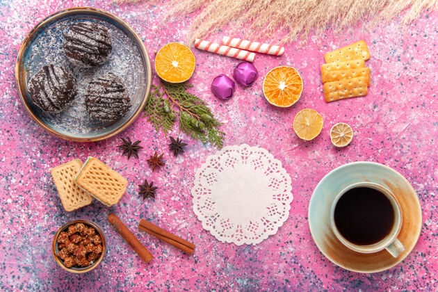 咖啡粉红色桌子上的巧克力蛋糕 华夫饼和一杯茶饼干糖果水果