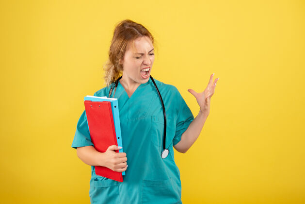 病毒黄色墙上穿着医疗服的女医生拿着不同的分析图护士分析西装