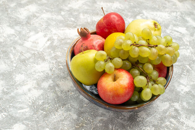 水果前视新鲜水果成分苹果葡萄等水果放在白色书桌上新鲜醇厚的水果成熟的颜色维生素桌子饮食生的