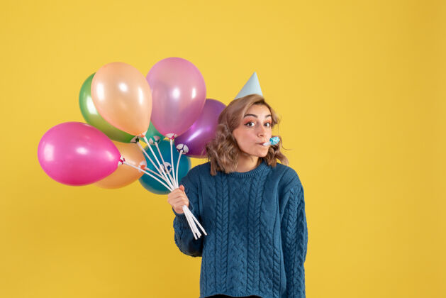 乐趣正面图：带着彩色气球的年轻女性气球年轻女性节日