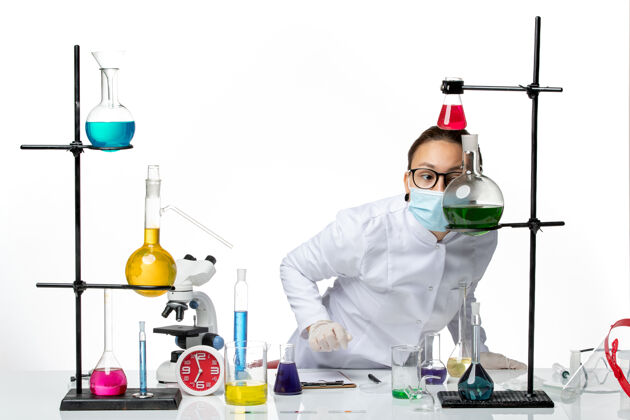 化学前视图身穿医疗服的女化学家戴着面罩 在白色背景上工作病毒化学实验室covidsplash药医疗病毒