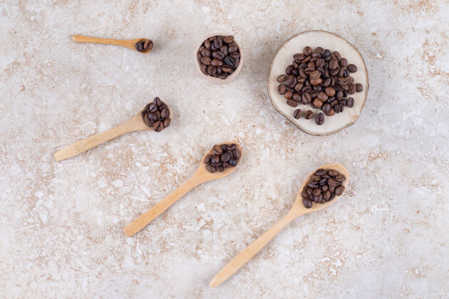 香喷喷的咖啡豆装在勺子上 一块木头和一个小杯杯子咖啡豆咖啡