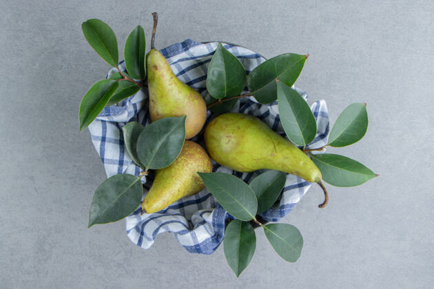 水果梨子和叶子放在一个碗里 用毛巾盖在大理石上风味营养美味