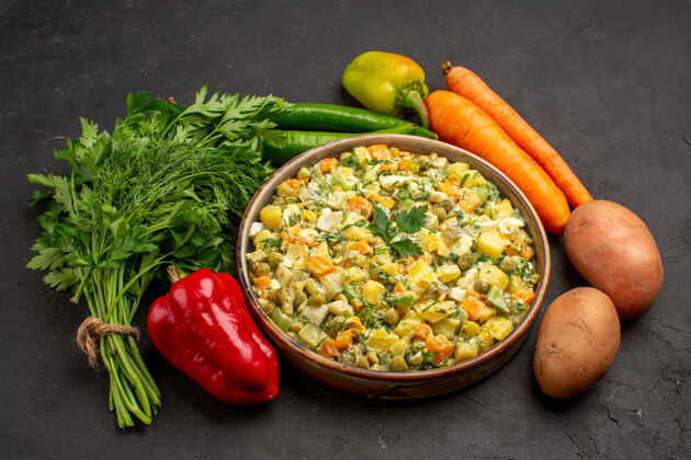 一餐在黑暗的表面上有蔬菜和蔬菜的美味沙拉的正面视图黑胡椒绿色食物