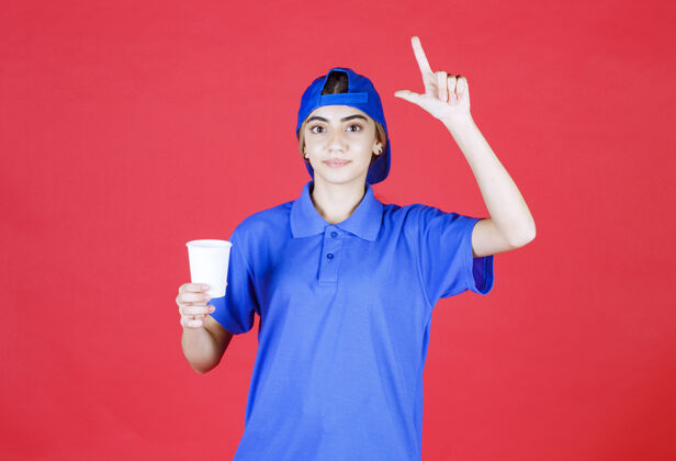 员工穿着蓝色制服的女服务人员拿着一杯一次性饮料 有个好主意塑料新服装
