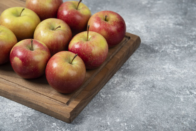 成熟用新鲜美味的苹果做成的木板放在大理石表面木材美味丰收