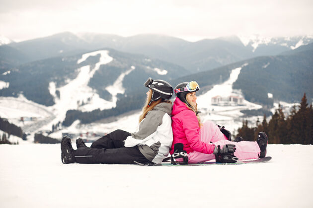 冷穿着滑雪板套装的女人在山上的运动员手拿滑雪板在地平线上关于运动的概念自然护目镜娱乐